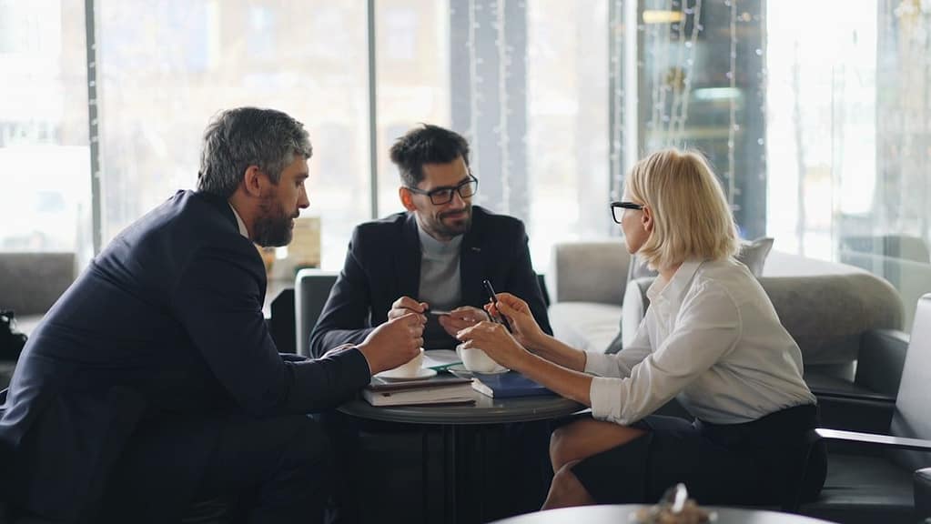 Reunião de planejamento sucessório entre sócios de empresa familiar em torno de uma mesa